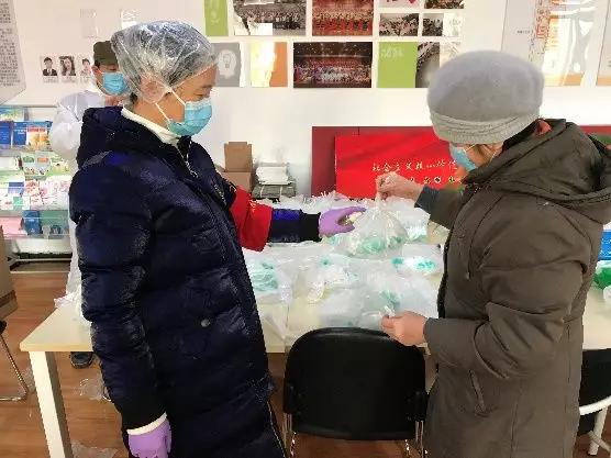 為樓棟分發(fā)口罩，并為包裝袋消毒